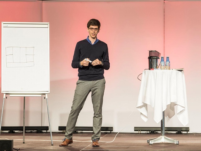 Fabio Sandmeier erklärt auf der Bühne den Key Message Canvas